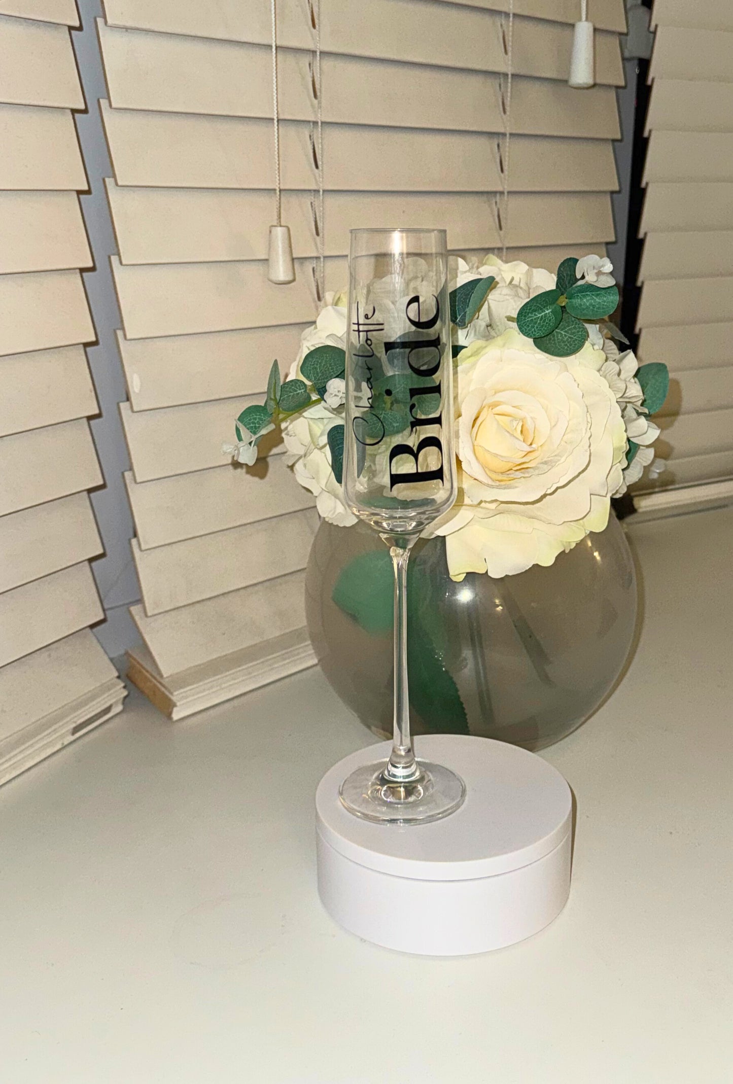 Decorative wine glass with 'Bride' text on a white surface.