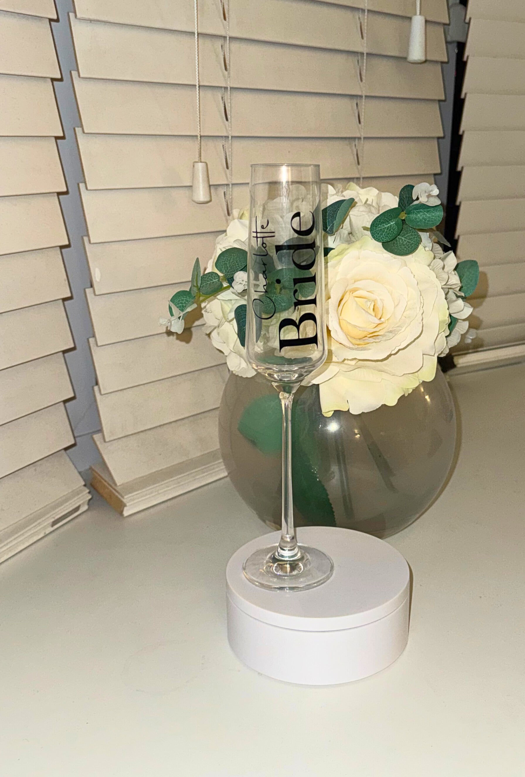 Decorative wine glass with 'Bride' text on a white surface.
